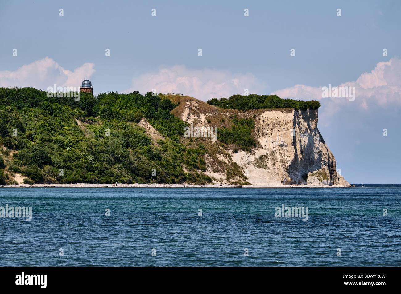 Steile weiße Kreidefelsen und üppiges Grün am Kap Arkona auf der Insel Rügen, mit teilweise sichtbarem Peilturm über dem Baumkronen Stockfoto
