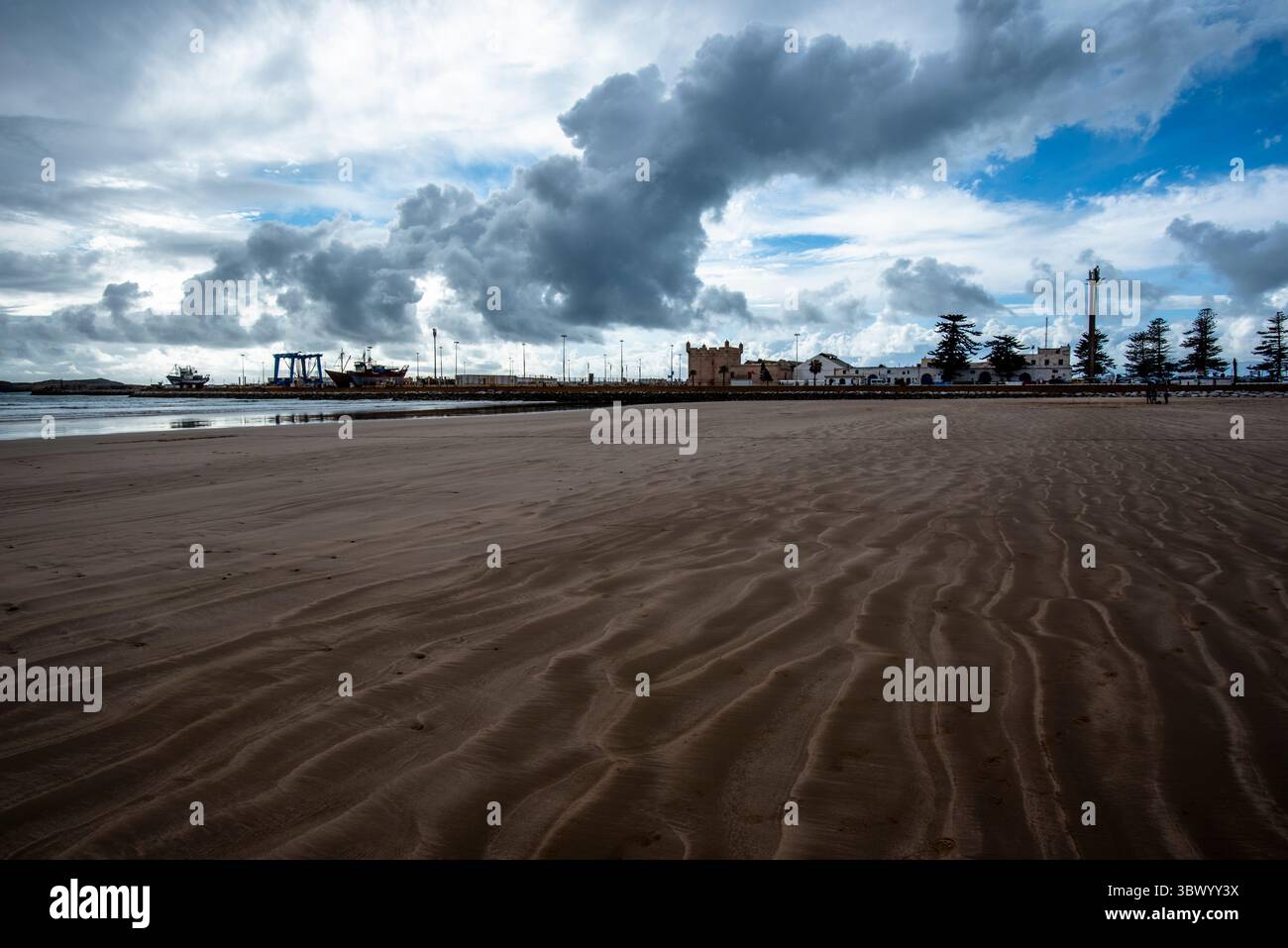 Wunderschöner Blick auf die riesigen Strände von Essaouira am Atlantischen Ozean mit dem Hafen und dem gelben Sand, dem blauen Himmel mit weißen Wolken in Moroc Stockfoto