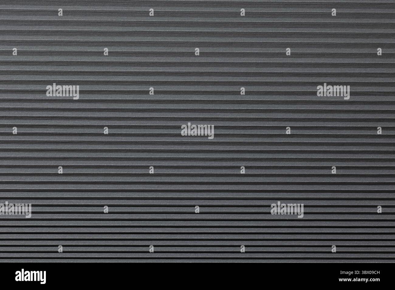 Eine strukturierte schwarze Oberfläche verfügt über gleichmäßig angeordnete parallele Linien, die ein Gefühl von Tiefe und Bemaßung erzeugen, ideal für Hintergründe oder moderne Designanwendungen. Stockfoto