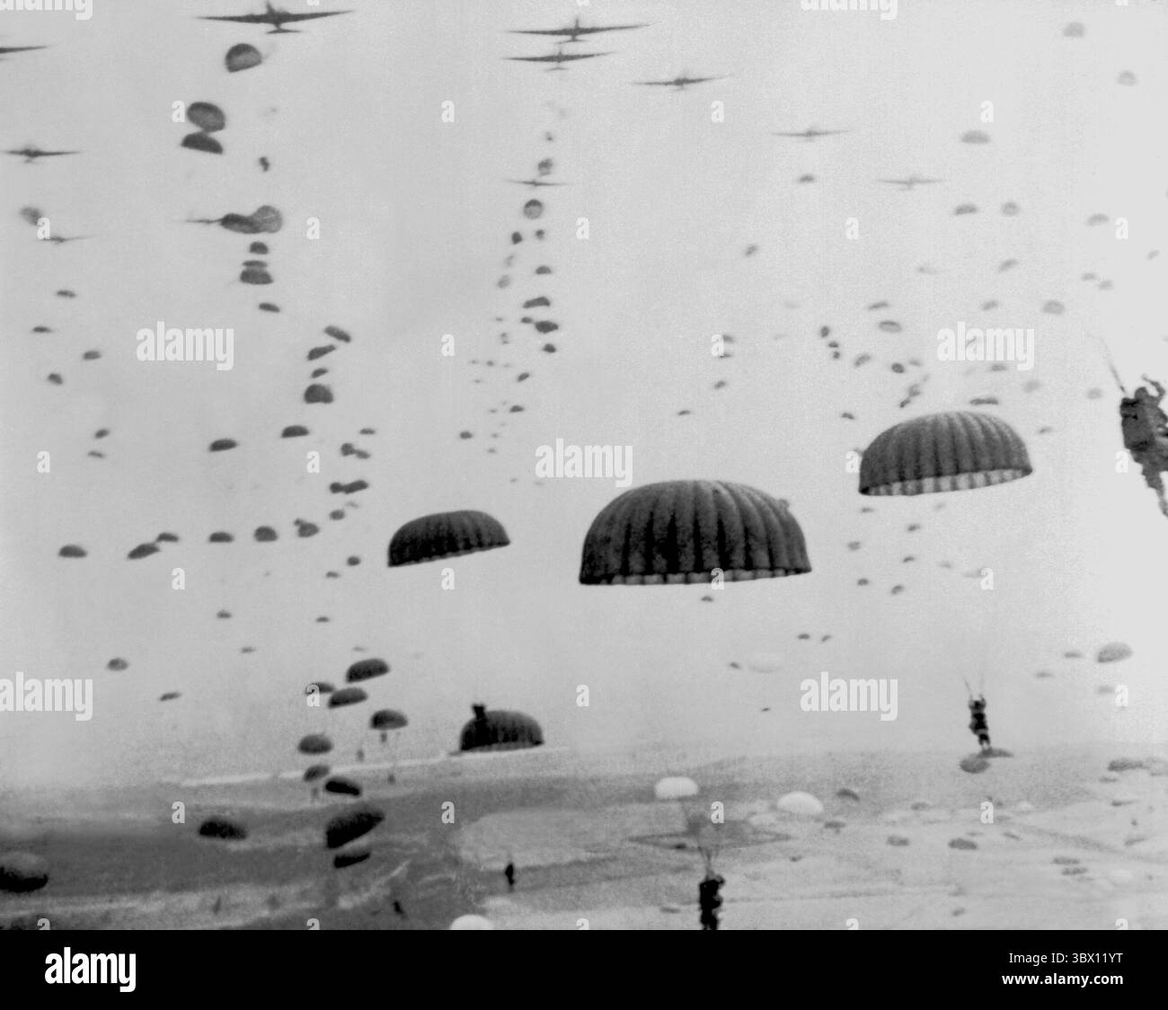 IN DER NÄHE VON ARNHEM, NIEDERLANDE, um den 17. September 1944, öffnen sich Fallschirmschirme, während Wellen von Fallschirmjägern in Holland während des Betriebs durch die niederländische Fluggesellschaft fallen Stockfoto