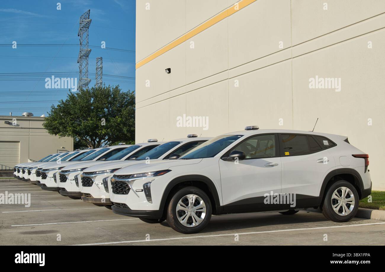 Houston, Texas, USA, 13. Juli 2025: Fahrzeuge der Flotte der White SUV-Firma, die in Reihe nach Lagerindustriebezirken angeordnet sind. Stockfoto