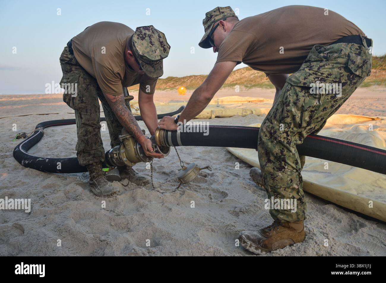 9. August 2021 – North Carolina, USA – Seemänner, die dem Navy Cargo Handling Battalion ein Setup-Gear für das verteilte Littoral Operational Fuel Transfer System (DLOFTS) auf Onslow Beach, N.C. als Teil der Large-Scale-Übung (LSE 2021), 9. August 2021 zugewiesen wurden. LSE 2021 zeigt die Fähigkeit der Navy, präzise, tödliche und überwältigende Kräfte weltweit über drei Kommandos, fünf nummerierte Flotten und 17 Zeitzonen hinweg einzusetzen. Das LSE 2021 kombiniert Live- und synthetische Trainingsfunktionen zu einer intensiven, robusten Trainingsumgebung. Es wird High-Fidelity-Schulungen und reale Operatoren verbinden Stockfoto