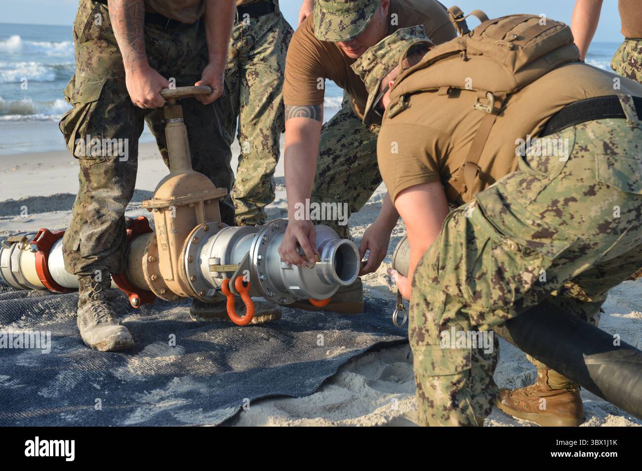 9. August 2021 – North Carolina, USA – Seeleute, die dem Navy Cargo Handling Battalion One Setup Gear für das Distributed Littoral Operational Fuel Transfer System (DLOFTS) am Onslow Beach, N.C. als Teil der Large-Scale-Übung (LSE 2021), 9. August 2021 zugewiesen wurden. LSE 2021 zeigt die Fähigkeit der Navy, präzise, tödliche und überwältigende Kräfte weltweit über drei Kommandos, fünf nummerierte Flotten und 17 Zeitzonen hinweg einzusetzen. Das LSE 2021 kombiniert Live- und synthetische Trainingsfunktionen zu einer intensiven, robusten Trainingsumgebung. Es wird High-Fidelity-Schulungen und reale Operatoren verbinden Stockfoto