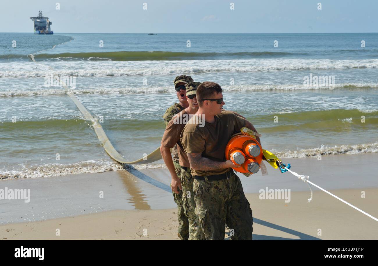 9. August 2021 – North Carolina, USA – die dem Navy Cargo Handling Battalion One zugewiesenen Seeleute richteten das verteilte Littoral Operational Fuel Transfer System (DLOFTS) am Strand Onslow, N.C. im Rahmen einer Großübung (LSE 2021) am 9. August 2021 ein. LSE 2021 zeigt die Fähigkeit der Navy, präzise, tödliche und überwältigende Kräfte weltweit über drei Kommandos, fünf nummerierte Flotten und 17 Zeitzonen hinweg einzusetzen. Das LSE 2021 kombiniert Live- und synthetische Trainingsfunktionen zu einer intensiven, robusten Trainingsumgebung. Es wird High-Fidelity-Schulungen mit realen Operationen verbinden Stockfoto