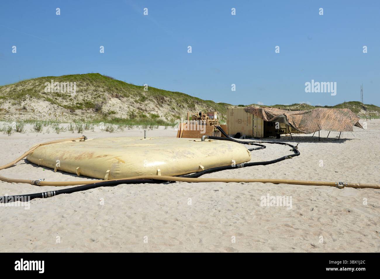 9. August 2021 – North Carolina, USA – Ein 20.000 Gallonen Faltbarer Stofftank wird mit Salzwasser gefüllt, als Test des verteilten Littoral Operational Fuel Transfer System (DLOFTS) des Navy Cargo Handling Battalion One am Onslow Beach, N.C. im Rahmen einer Großübung (LSE 2021), 9. August 2021. LSE 2021 zeigt die Fähigkeit der Navy, präzise, tödliche und überwältigende Kräfte weltweit über drei Kommandos, fünf nummerierte Flotten und 17 Zeitzonen hinweg einzusetzen. Das LSE 2021 kombiniert Live- und synthetische Trainingsfunktionen zu einer intensiven, robusten Trainingsumgebung. Das wird sich ergeben Stockfoto
