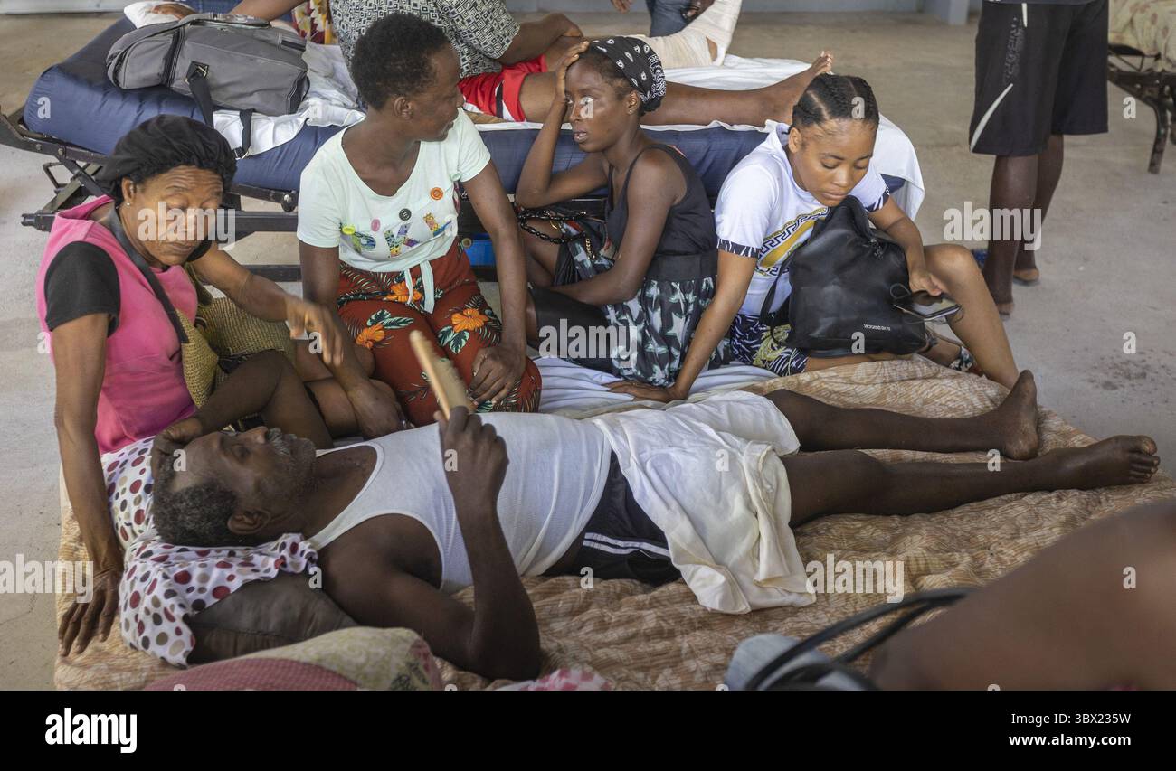 16. August 2021, Les Cayes, Haiti: Ein Mann, der während des Erdbebens verletzt wurde, liegt in Begleitung seiner Familie auf einer Decke im Krankenhaus Center de Sante Lumiere in Les Cayes, Haiti. Es ist bekannt, dass mindestens 1.297 Menschen während des Beben der Stärke 7,2 gestorben sind und eine unbekannte Zahl fehlt noch. (Foto: © Jose A. Iglesias/Miami Herald/TNS via ZUMA Press Wire) Stockfoto