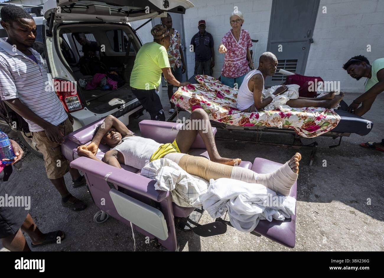 16. August 2021, Les Cayes, Haiti: Zwei Männer warten am Montag, den 16. August 2021, auf den Rücksitz eines Lieferwagens im Krankenhaus Center de Sante Lumiere in Les Cayes, Haiti. Sie werden zum Flughafen gebracht, damit die US-Küstenwache sie nach Port-au-Prince fliegen kann. Es ist bekannt, dass mindestens 1.297 Menschen während des Beben der Stärke 7,2 gestorben sind und eine unbekannte Zahl fehlt noch. (Foto: © Jose A. Iglesias/Miami Herald/TNS via ZUMA Press Wire) Stockfoto
