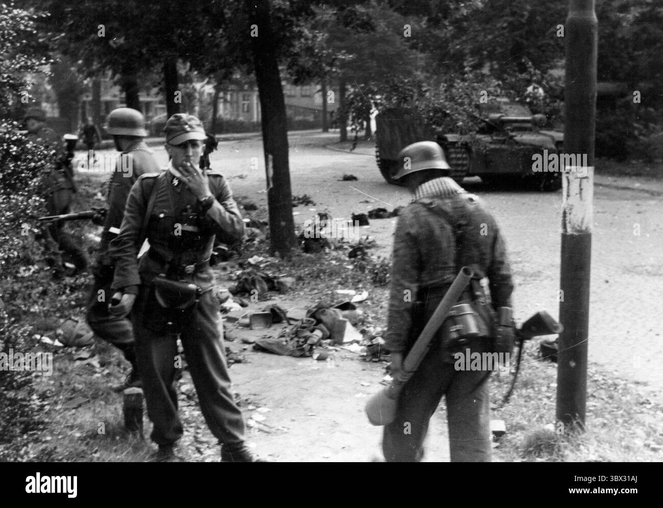 ARNHEIM, NIEDERLANDE - 17. September 1944 - deutsche Soldaten suchen nach Ausrüstung, die während der Kämpfe in Arnheim, der Nethe, auf den Straßen zurückgelassen wurde Stockfoto