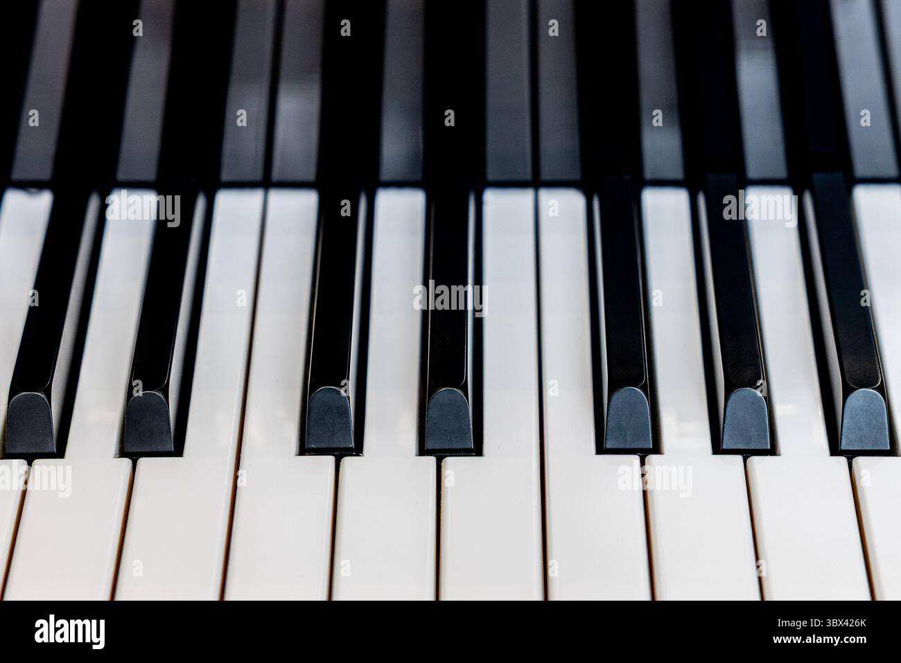 Ein detailliertes Nahfoto von schwarz-weißen Klaviertasten, das die klare Symmetrie und das elegante Design einer Musiktastatur zeigt. Diese hohe Auflösung Stockfoto