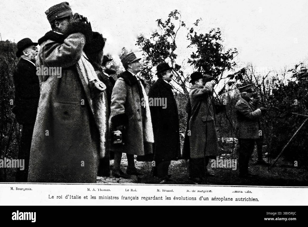 König Viktor Emmanuel III. Von Italien und die französischen Minister Aristide Briand, Albert Thomas und andere beobachten die Manöver eines österreichischen Flugzeugs während des Ersten Weltkriegs. Das in L’Illustration aufgezeichnete Bild spiegelt die Koordination der alliierten Kriegszeit an der italienischen Front im Februar 1916 wider und hebt die Bedenken hinsichtlich der Luftaufklärung und der wachsenden Rolle der Luftmacht im Krieg hervor. Stockfoto