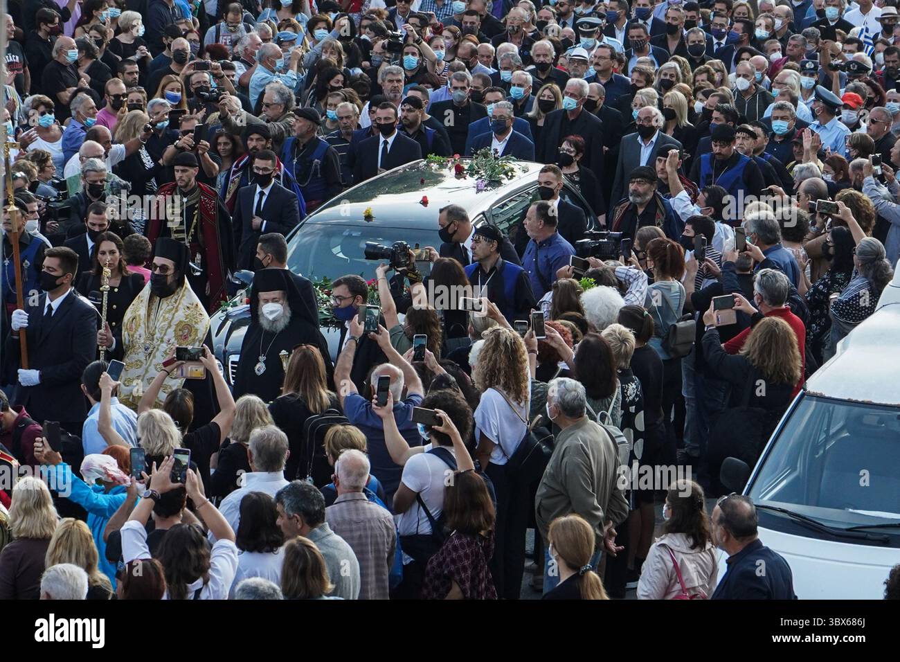 9. September 2021, Insel Chania Kreta, Griechenland: Männer in traditioneller Kleidung der Insel Kreta und Menschen eskortieren einen Leichenwagen, vor der Beerdigung des späten griechischen Komponisten Mikis Theodorakis auf der Insel Chania Kreta. Er verfasste eine breite Palette von Werken, von düsteren Sinfonien bis hin zu populären TV- und Filmmusiken, darunter für „Serpico“ und „Zorba the Greek“. Er ist auch für seine Opposition gegen die Militärjunta bekannt, die Griechenland von 1967 bis 1974 regierte, als er verfolgt und inhaftiert wurde und seine Musik verboten wurde. (Kreditbild: © Eurokinissi via ZUMA Press Wire) Stockfoto