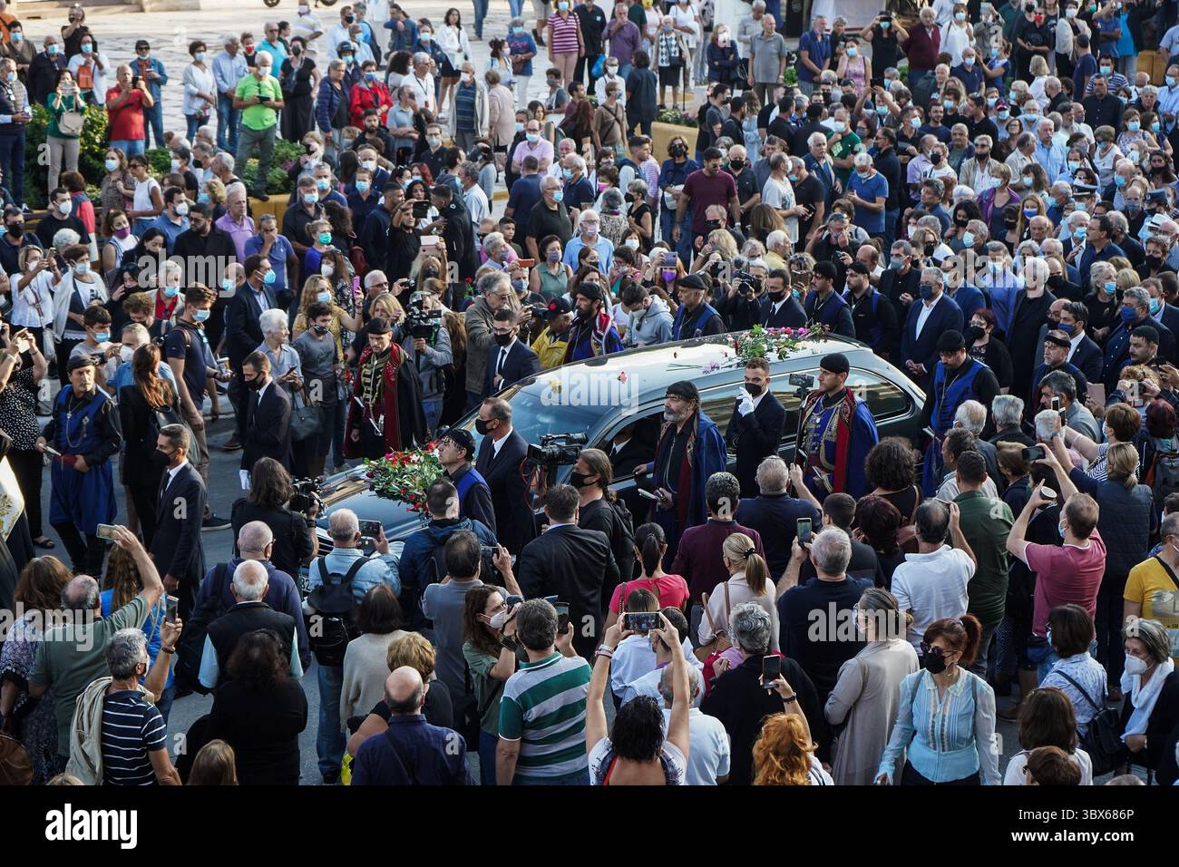 9. September 2021, Insel Chania Kreta, Griechenland: Männer in traditioneller Kleidung der Insel Kreta und Menschen eskortieren einen Leichenwagen, vor der Beerdigung des späten griechischen Komponisten Mikis Theodorakis auf der Insel Chania Kreta. Er verfasste eine breite Palette von Werken, von düsteren Sinfonien bis hin zu populären TV- und Filmmusiken, darunter für „Serpico“ und „Zorba the Greek“. Er ist auch für seine Opposition gegen die Militärjunta bekannt, die Griechenland von 1967 bis 1974 regierte, als er verfolgt und inhaftiert wurde und seine Musik verboten wurde. (Kreditbild: © Eurokinissi via ZUMA Press Wire) Stockfoto