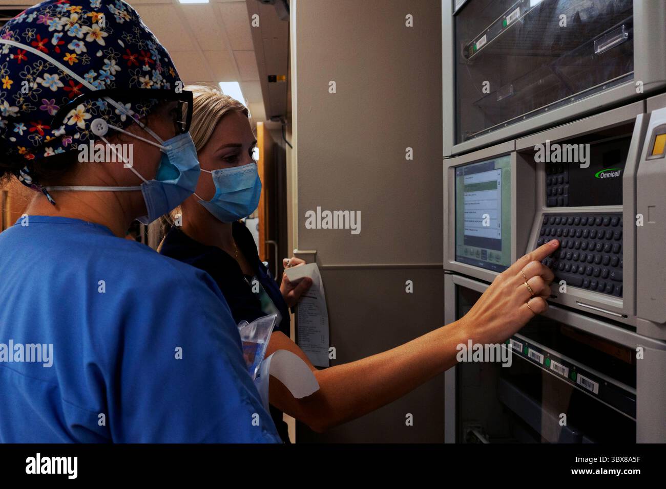 September 2021 - Lafayette, Louisiana, USA - (von links nach rechts) U.S. Navy Lt. Commander. Sarah Hull, eine klinische Pflegespezialistin für die Intensivmedizin mit Naval Medical Readiness and Training Command, und Mattie Delahoussaye, Krankenschwester Manager für 6 Ward im Ochsner Lafayette General Medical Center, erhalten Zugang zu medizinisch kontrollierten Substanzen aus einer Lagereinheit für Krankenhauspatienten in Lafayette, Louisiana, 2. September 2021. Das U.S. Northern Command ist durch die U.S. Army North weiterhin entschlossen, die gesamte Regierung mit COVID-19-Maßnahmen flexibel zu unterstützen. (Foto-Illustration von Sgt. 1. Klasse Timoth Stockfoto
