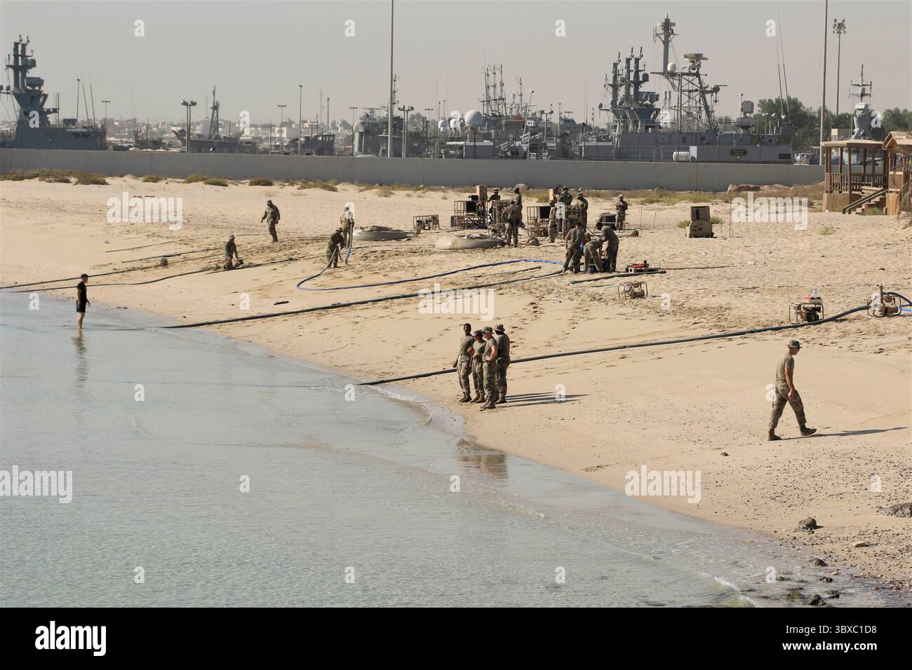 23. September 2021 – Kuwait Naval Base, USA – die Task Force Phoenix Soldaten verbündeten sich mit aktiven Dienst- und Reservesoldaten des 393. Combat Sustainment Support Battalion, der 526. Quartermaster Composite Supply Company und der 247. Composite Supply Company für die Operation Dursty Camel. Die Operation fand über vier Tage auf der Kuwait Marinebasis am Persischen Golf statt. Die Soldaten der Task Force Phoenix vom 640. Aviation Support Battalion nutzten ihre Fähigkeiten als 92W Water Treatment Specialists, um Salzwasser aus dem Golf zu pumpen und in Trinkwasser umzuwandeln. Während des Vorgangs wird der so Stockfoto
