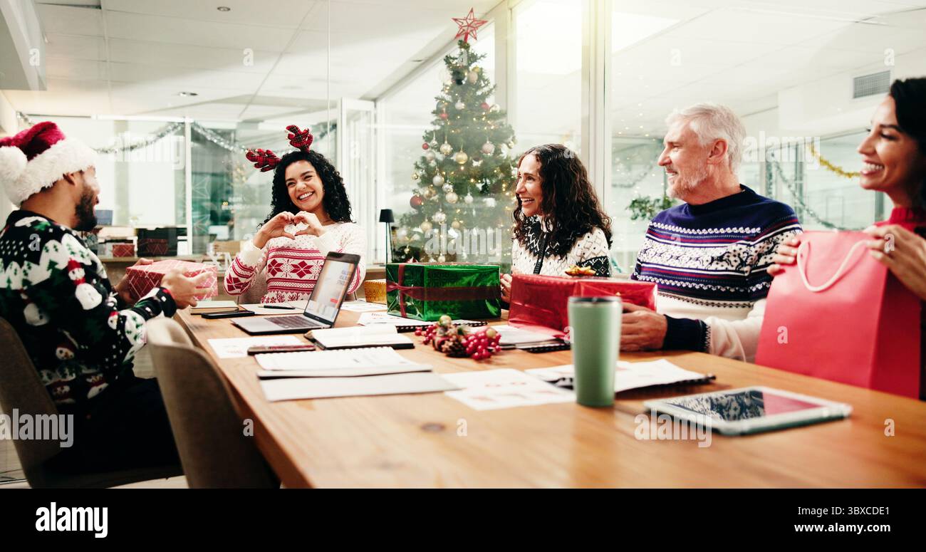 Weihnachten, Geschäftsleute und Tausch-Geschenk in Bürofeier mit Herzhänden für Dankbarkeit. Weihnachten, glückliche Arbeiter oder Geschenke mit Liebe für Stockfoto