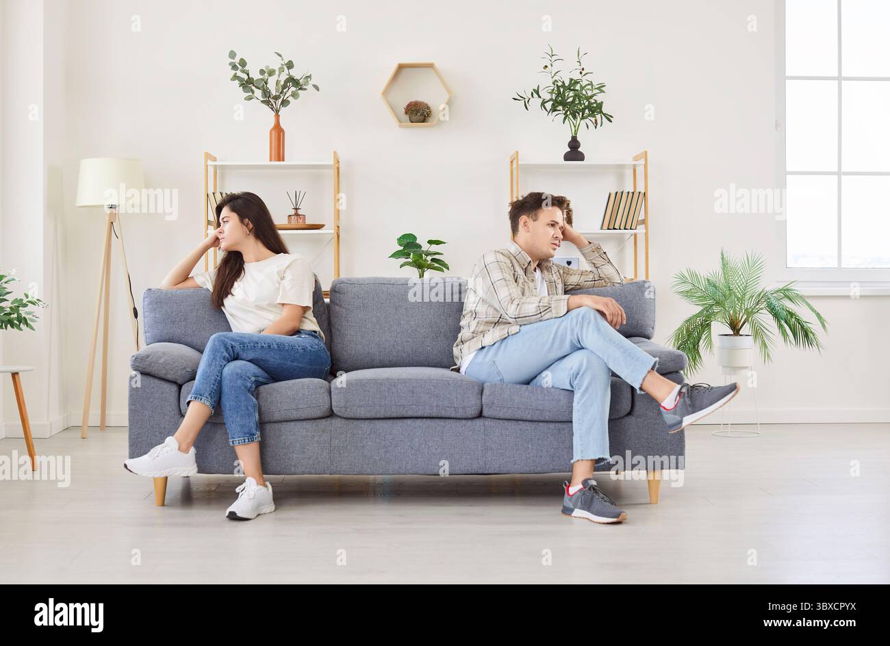 Familienpaar, das auf der Couch sitzt, beleidigt und traurig zu Hause Stockfoto