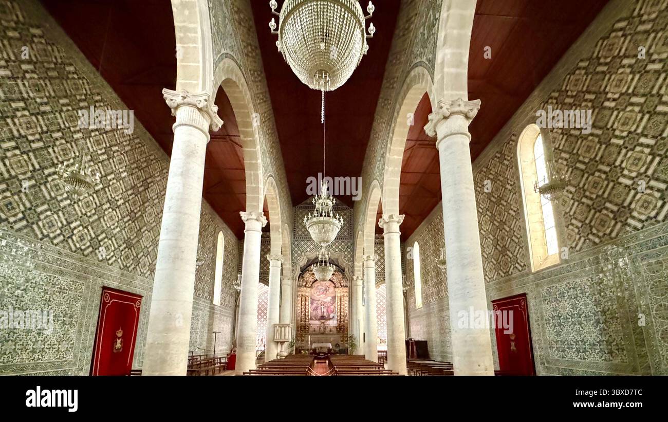 Das Innere der Kirche Santa Maria de Marvila mit Kronleuchtern, Bögen und Azulejos-Fliesen an der Wand, Santarem Portugal. - Smartphone-aufgenommenes Stockfoto