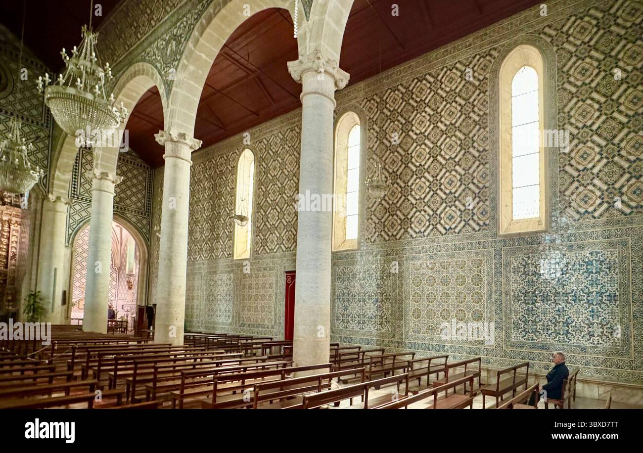 Das Innere der Kirche Santa Maria de Marvila mit Kronleuchtern, Bögen und Azulejos-Fliesen an der Wand, Santarem Portugal. - Smartphone-aufgenommenes Stockfoto