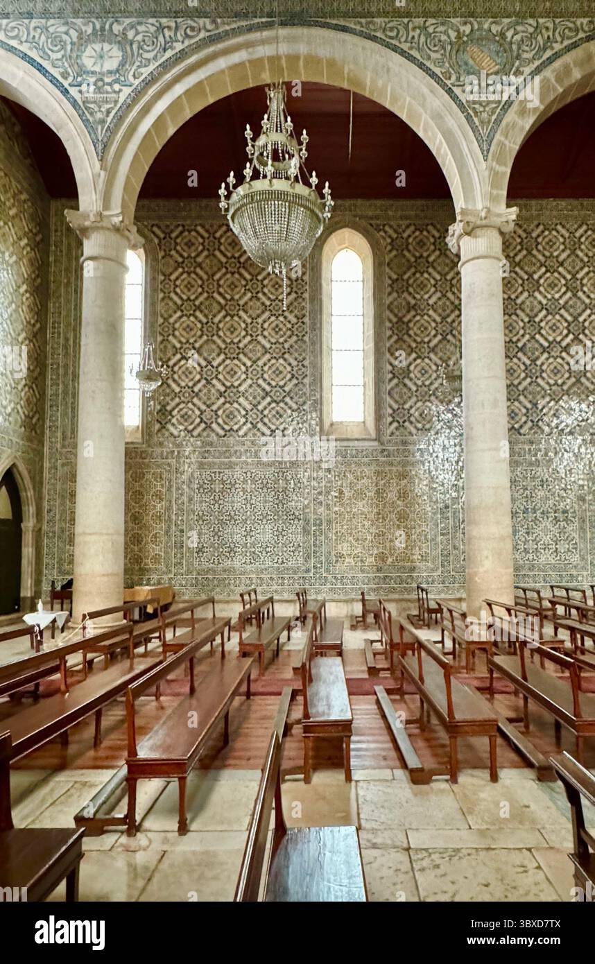 Das Innere der Kirche Santa Maria de Marvila mit Kronleuchtern, Bögen und Azulejos-Fliesen an der Wand, Santarem Portugal. - Smartphone-aufgenommenes Stockfoto