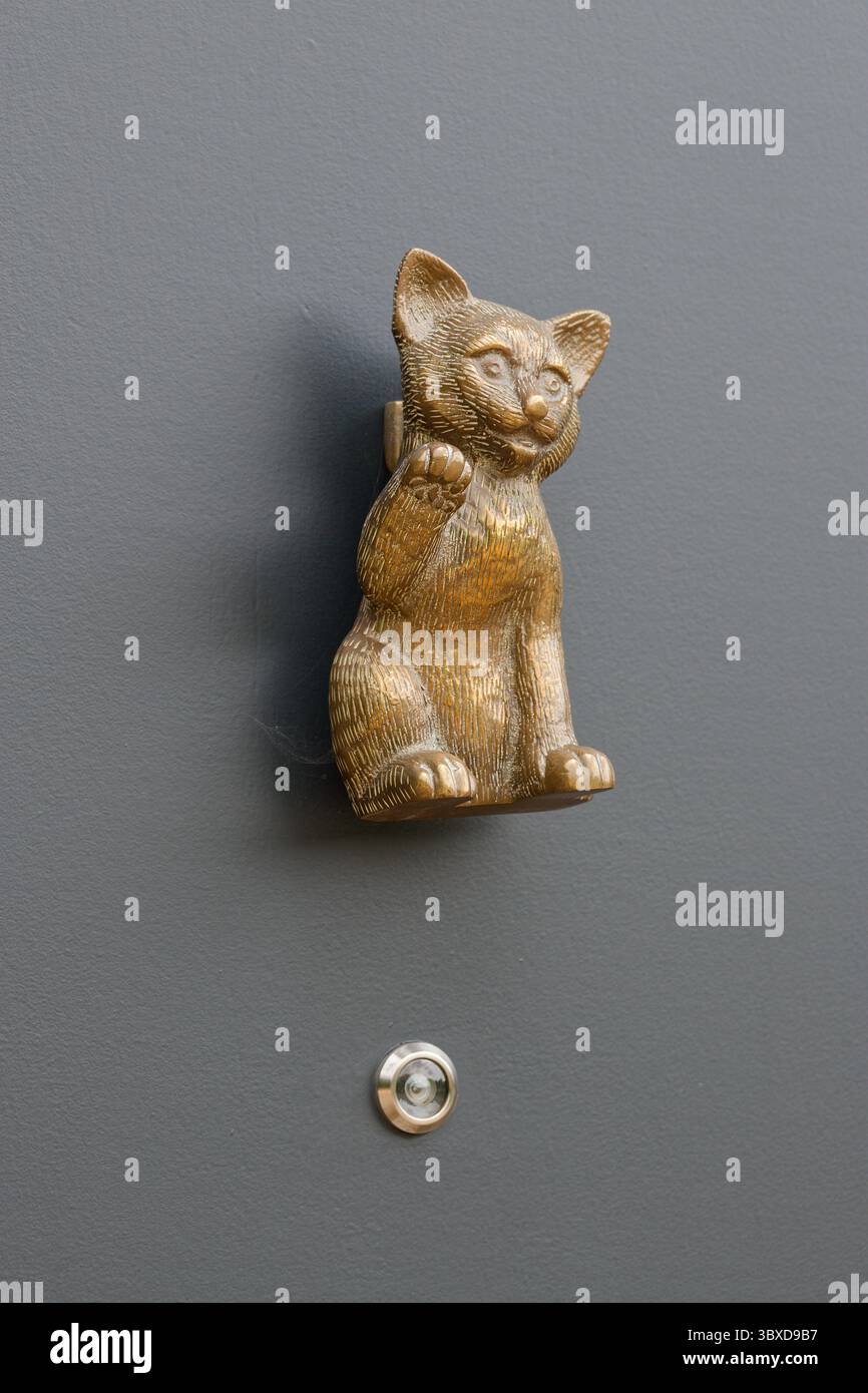 Japaner, Chinesen und Asiaten, die Figur einer winkenden Katze soll Glück bringen. Eine Pfote hoch in einer winkenden Geste. Türklopfer. Stockfoto