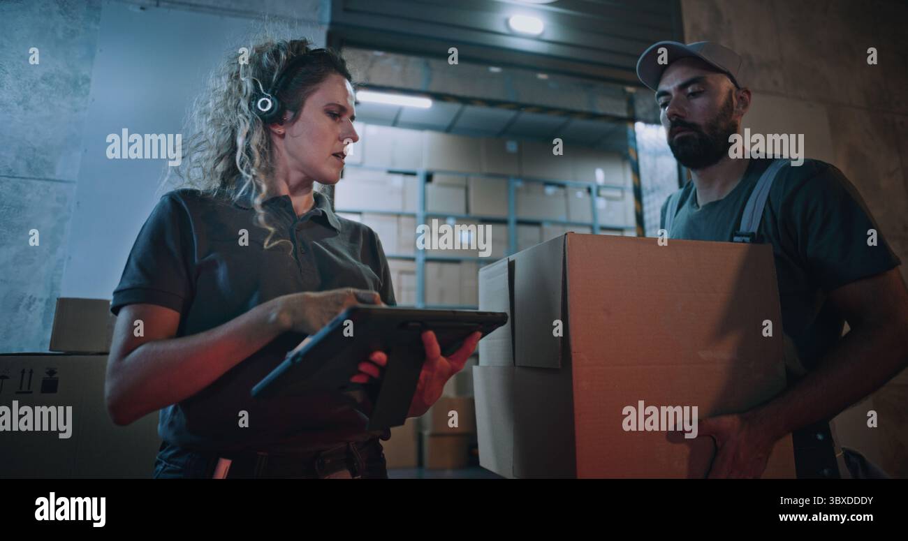 Weibliche Inventory Manager scannt Kartonschachteln mit Strichcode-Scanner mit Tablet-Computer. Multiethnische Arbeiter, die Pakete mit Online-Bestellungen transportieren, Waren aus dem Logistikeinzelhandelslager nachts. Stockfoto