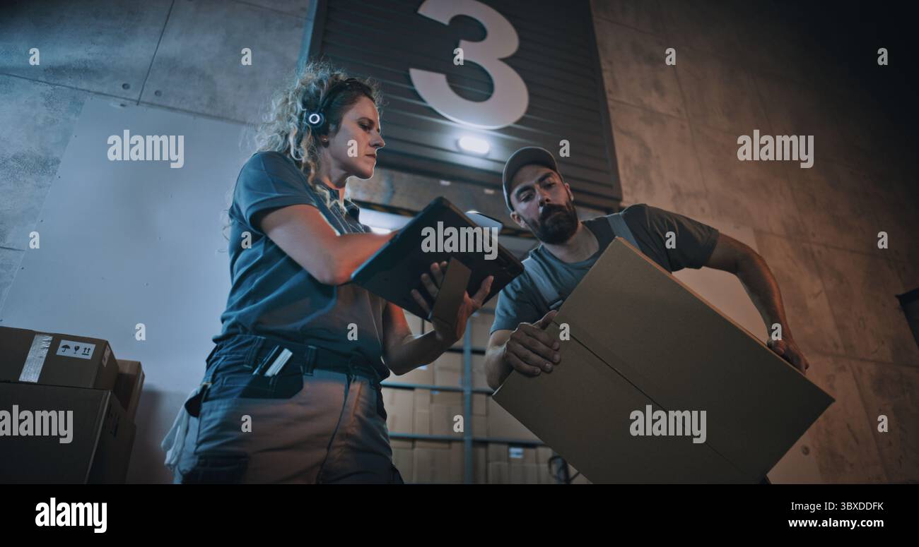 Weibliche Manager scannt Pakete mit Barcode-Scanner mit Digital Tablet. Verschiedene Mitarbeiter, die nachts Kartons aus dem Logistics Distribution Warehouse transportieren. Online-Bestellungen, Waren, Lieferung. Stockfoto