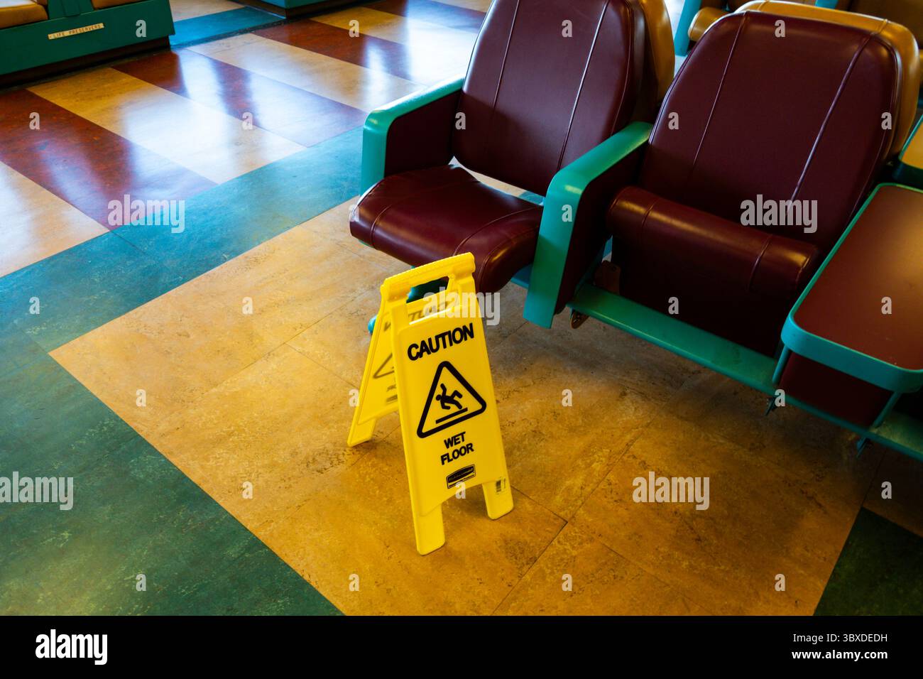 Schilder warnen vor rutschigen Böden auf dem Innendeck einer Fähre. Stockfoto