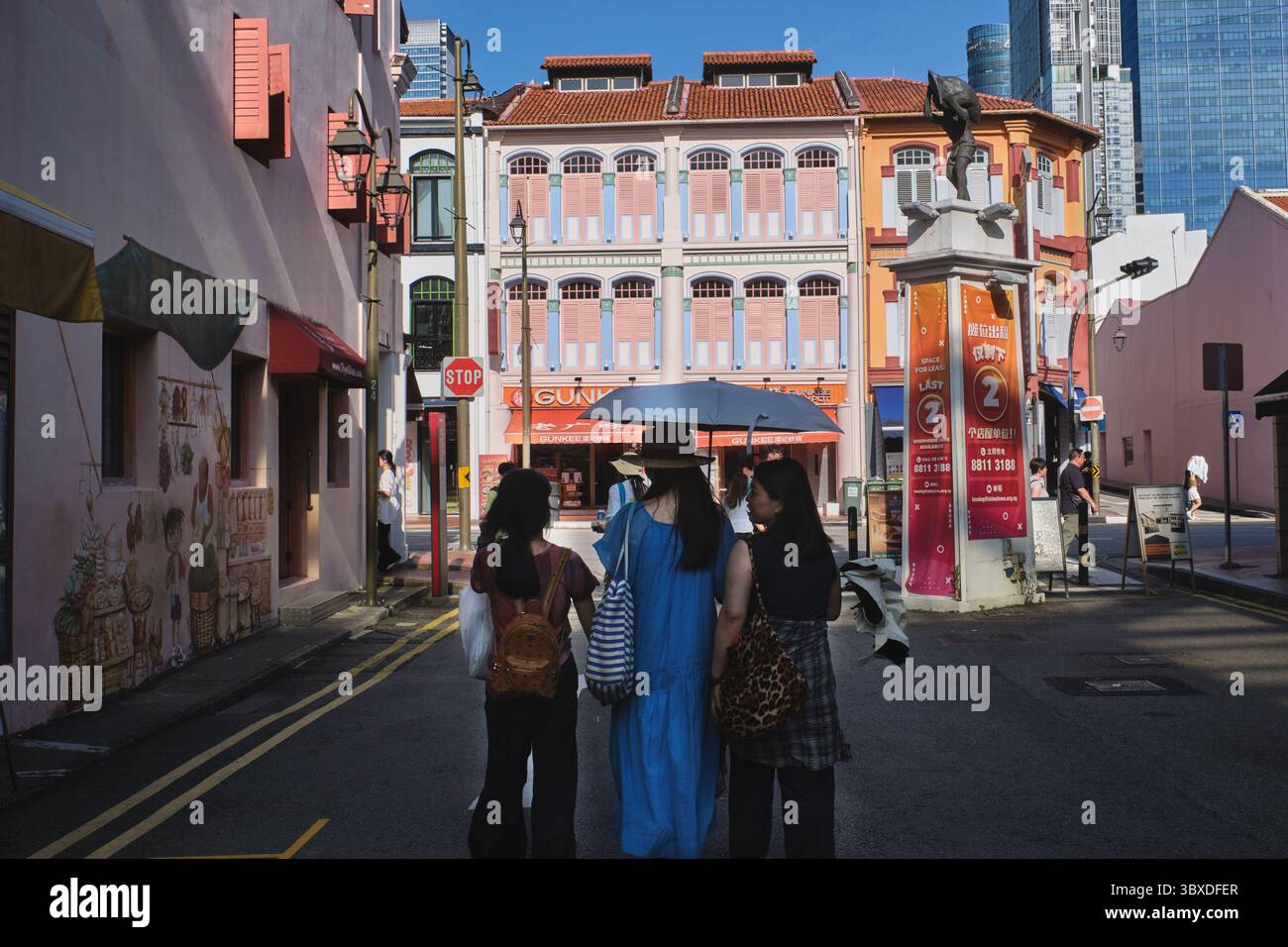 Asiatische Touristen in Smith St., Chinatown, Singapur, die in Richtung South Bridge Rd. Schauen Und ein attraktives, dreistöckiges traditionelles altes Ladenlokal Stockfoto