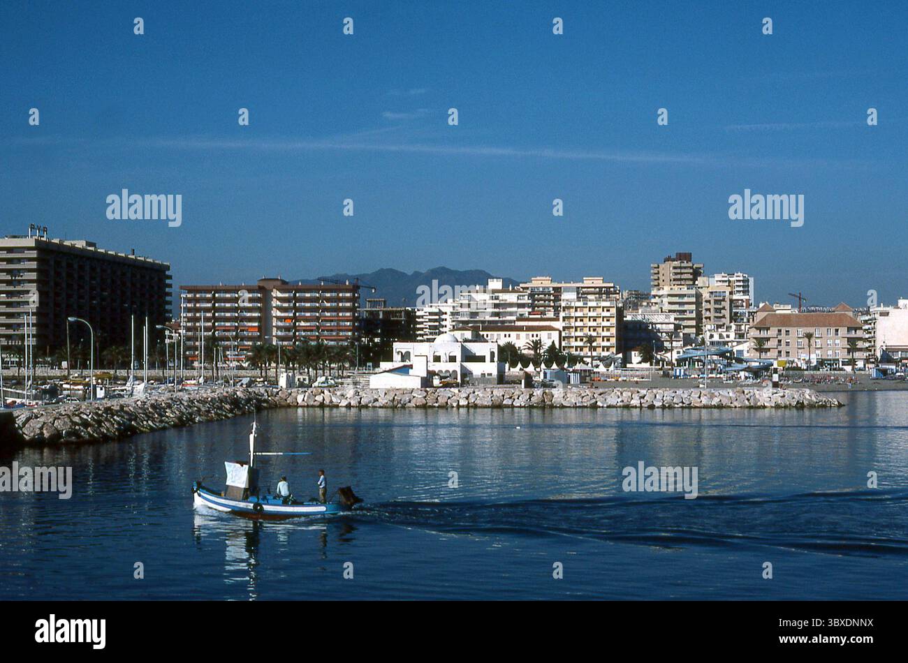 Spanien der 1980er Jahre - Fischerboot nähert sich 1983 dem Hafen von Fuengirola, Málaga Stockfoto