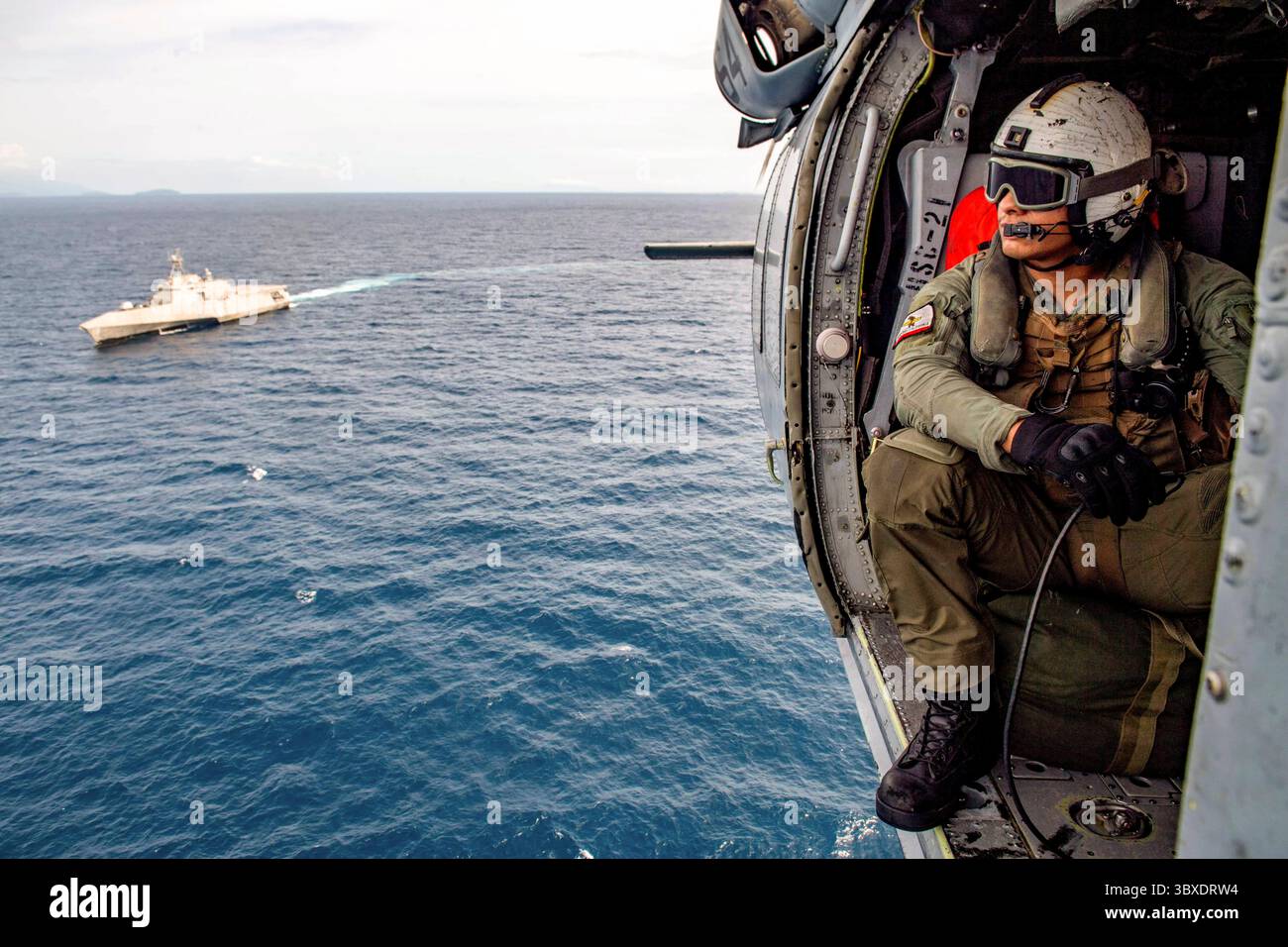 11. Oktober 2021 - Sulu Sea - Naval Air Crewman (Hubschrauber) 2. Klasse Javier Rosas aus San Mateo, Kalifornien, sitzt in einem MH-60S Sea Hawk Hubschrauber, der der Ã’BlackjacksÃ“ des Helicopter Sea Combat (HSC) Squadron (HSC) 21 während des Routineflugs mit dem Independence-Variante-Kampfschiff USS Charleston (LCS 18) zugeteilt ist. Charleston, Teil der Destroyer Squadron (DESRON) 7, befindet sich im Einsatzgebiet der 7. US-Flotte, um die Interoperabilität mit Partnern zu verbessern und als Bereitschaftstruppe zur Unterstützung der freien und offenen indopazifischen Region zu dienen. (phot Stockfoto