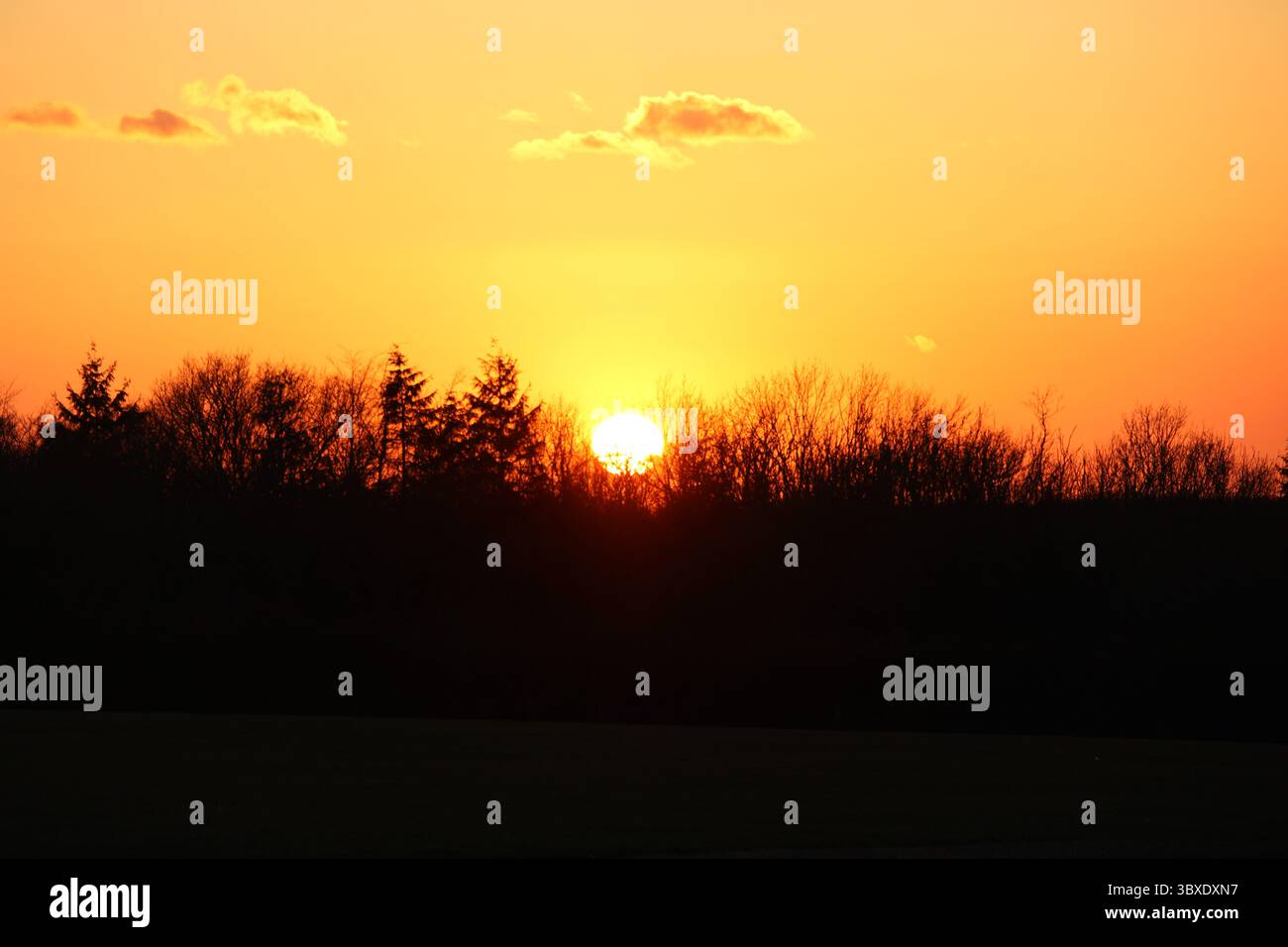 Dieses Bild zeigt eine ruhige Szene bei Sonnenuntergang. Die Sonne ist tief am Horizont. Stockfoto