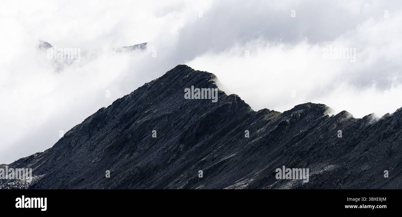 Bergkamm mit Zunderspitz und Gipfelkreuz, bewölkt, Stubaier Alpen, bei Ridnaun, Südtirol, Italien Stockfoto