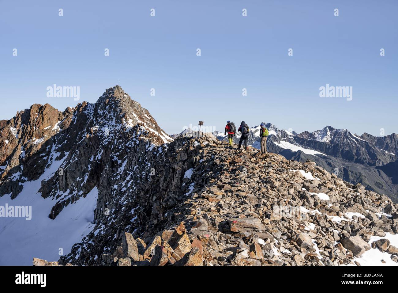 Bergsteiger auf einem Kamm, im Hintergrund Gipfel Wilder Freiger mit Gipfelkreuz, Stubaier Alpen, Südtirol, Italien Stockfoto