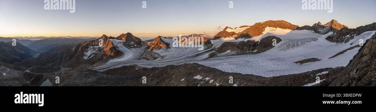 Malerische Hochgebirgslandschaft bei Sonnenaufgang mit alpenglow, Gletscher und felsigen Berggipfeln im Morgenlicht, Blick auf Becher der Berggipfel Stockfoto