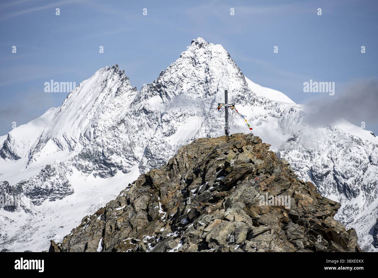 Gipfelkreuz des Gipfels Boeses Weibl, hinter dem Gipfel des Großglockners mit Schnee, Schober-Gruppe, Nationalpark hohe Tauern, Kärnten, Österreich Stockfoto