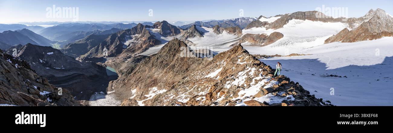 Bergsteiger auf einem felsigen Kamm auf dem Wilden Freiger Gipfel, hinter Signalgipfel und Becher Gipfel mit Becherhaus, malerische Hochgebirgslandschaft Stockfoto