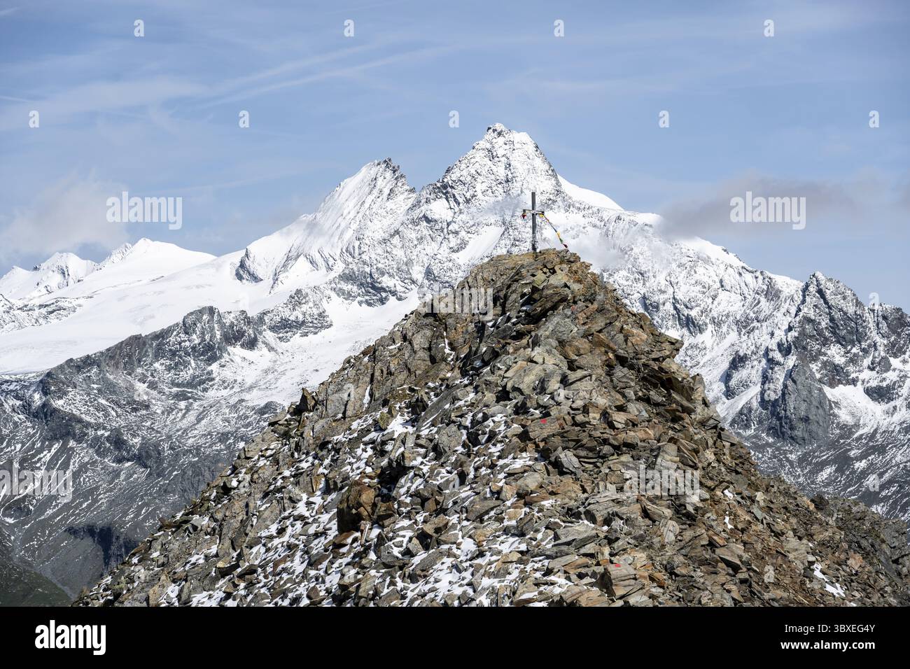 Gipfelkreuz des Gipfels Boeses Weibl, hinter dem Gipfel des Großglockners mit Schnee, Schober-Gruppe, Nationalpark hohe Tauern, Kärnten, Österreich Stockfoto