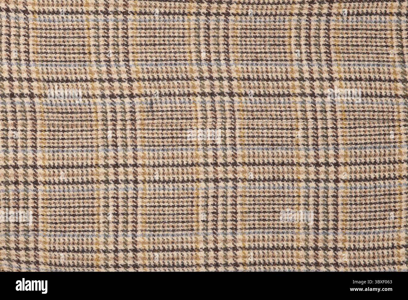 Karomuster aus Wolle. Weiche und warme gefaltete Alpakawolldecke. Makroshot mit karierter Struktur aus grüner und orangefarbener Wolle. Wollmantel Stockfoto