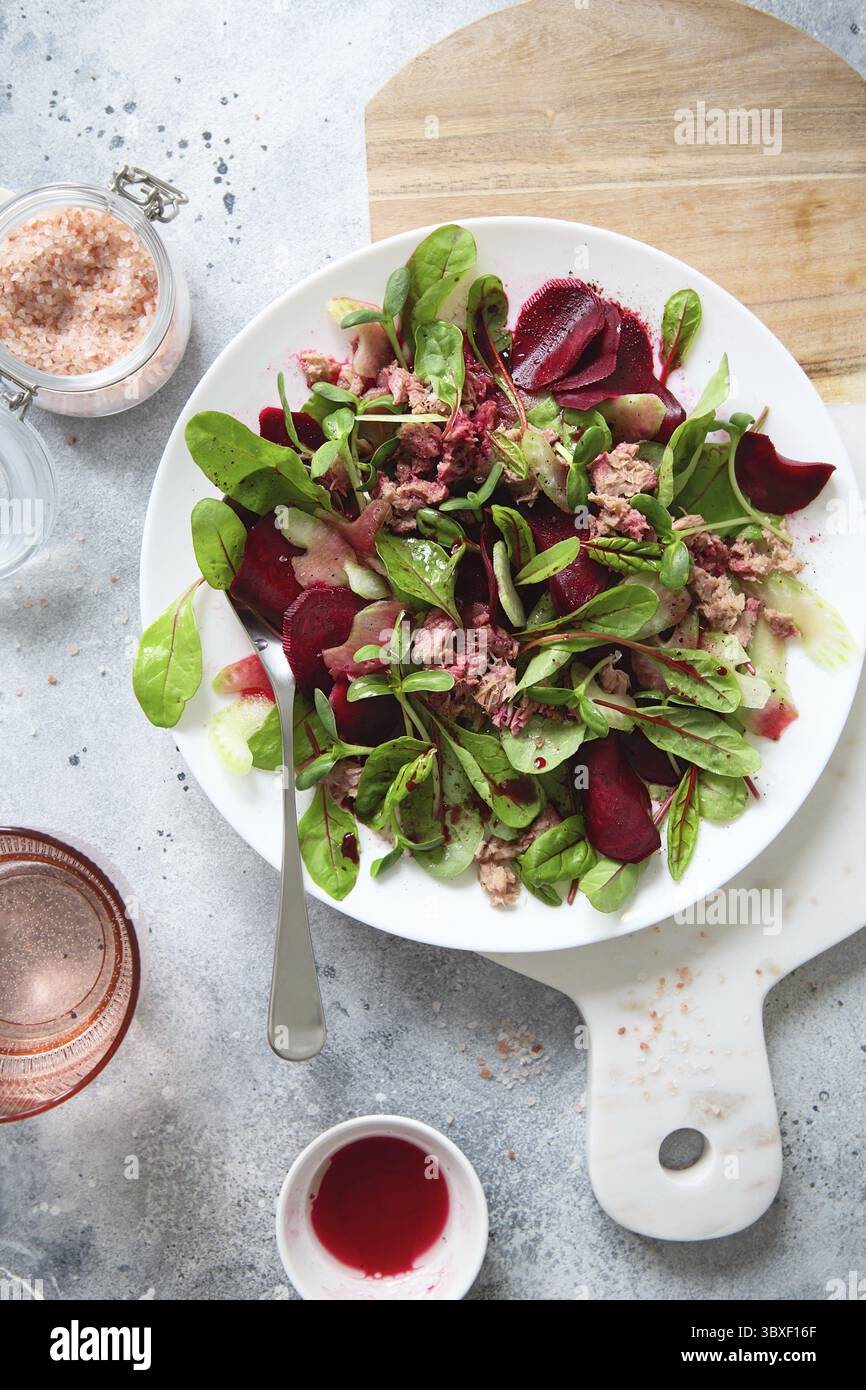 Gesunder, frischer Salat. Rote Bete, rote Mangold und Thunfischkonserven. Gesunde Mahlzeit Rezept Zubereitung. Gerichte auf pflanzlicher Basis. Grünes Leben. Vegetarische Rezepte. Stockfoto