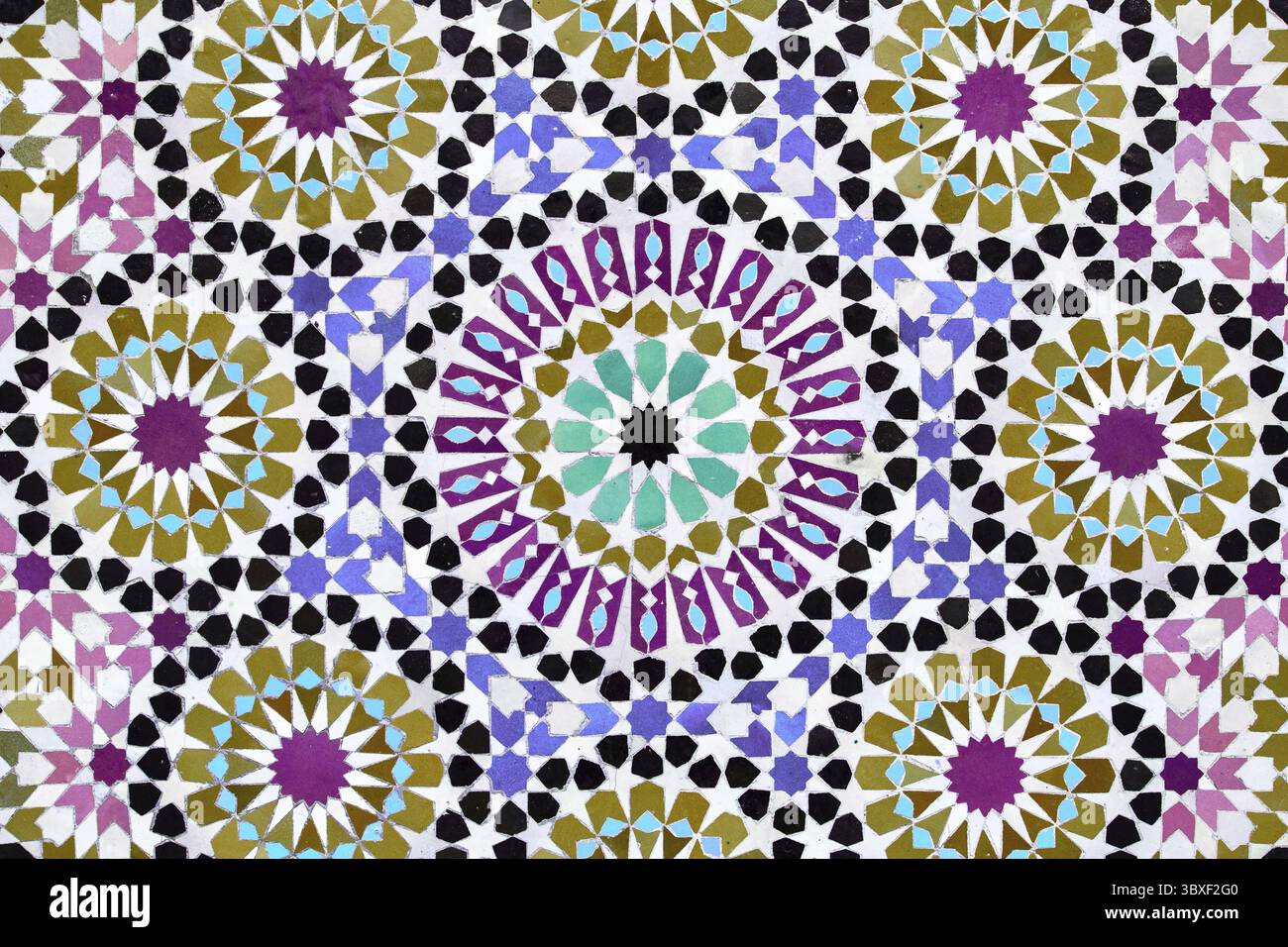 Ein detailliertes islamisches geometrisches Mosaik mit lebhaften Farben und symmetrischen Mustern. Das Design zeigt traditionelle Arabesken-Motive mit Sternscha Stockfoto