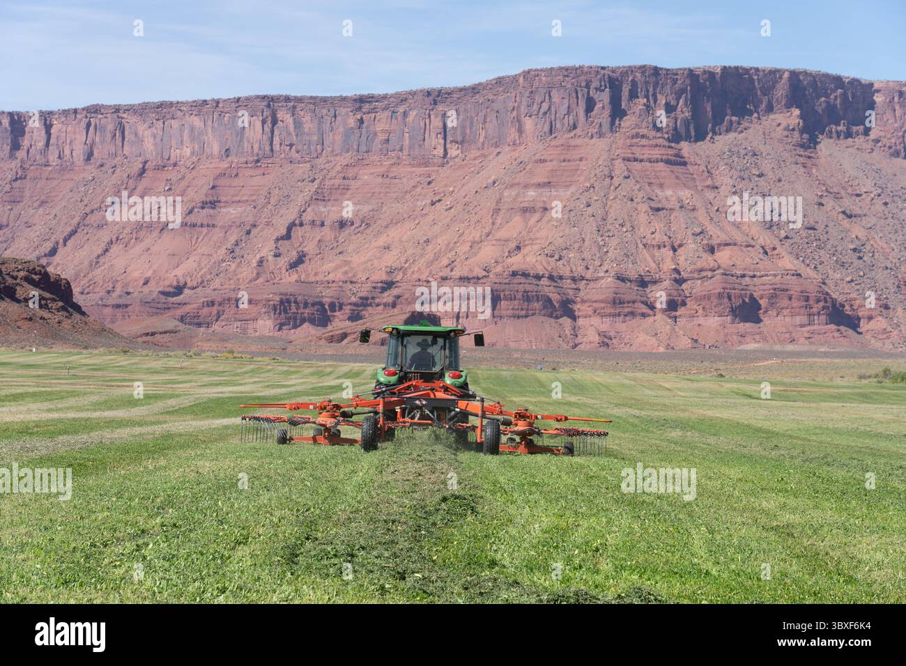 4. Oktober 2021, Moab, Utah, Vereinigte Staaten: Ein Rancher betreibt auf einer landschaftlich reizvollen Ranch im Red-Rock-Canyon-Land von Utah einen rotierenden Heu-Rechen hinter einem Traktor. (Kreditbild: © Jon G. Fuller/VW Pics via ZUMA Press Wire) Stockfoto