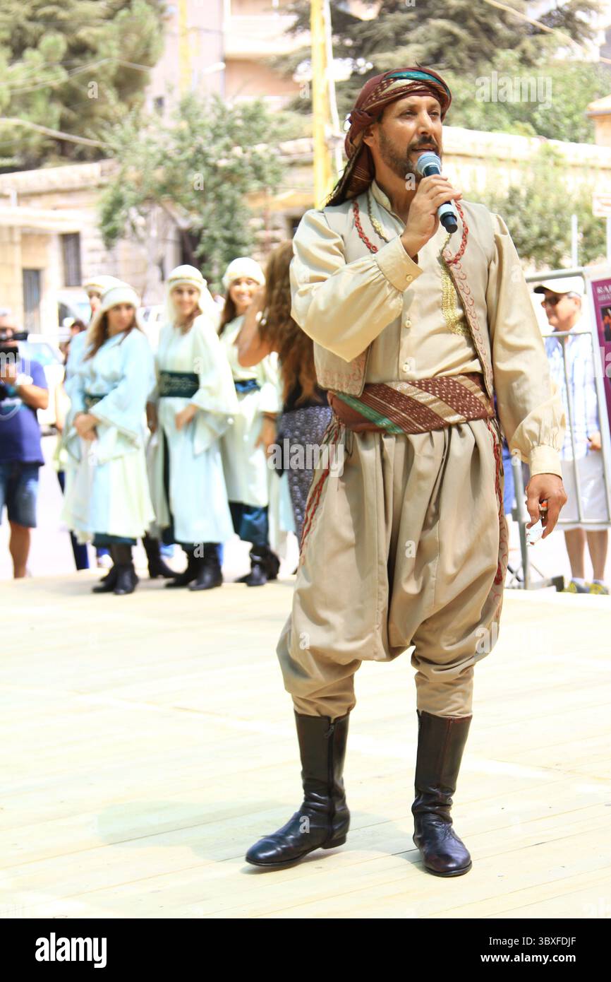 Lebendige, im Sommer im Libanon stattfindende kulturelle Tanzveranstaltung mit Darstellern in traditioneller Kleidung. Stockfoto
