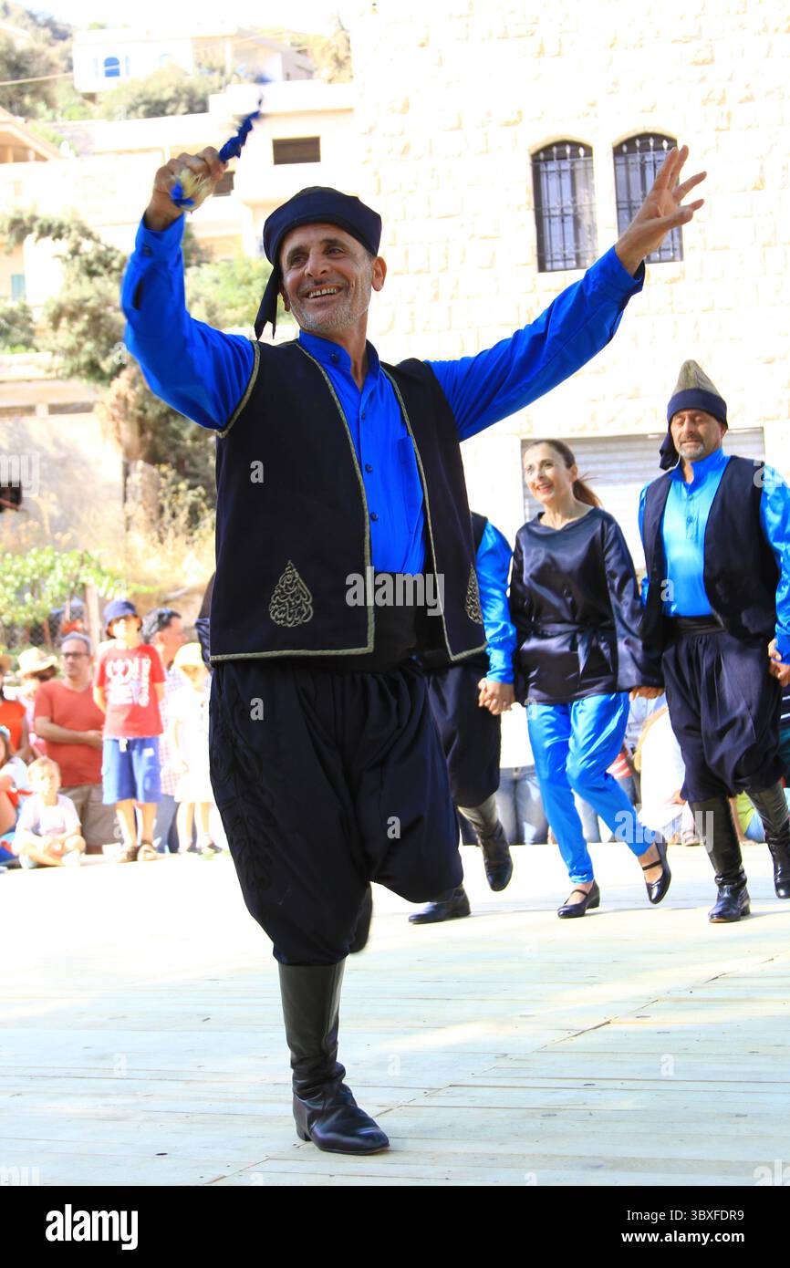 Lebendige, im Sommer im Libanon stattfindende kulturelle Tanzveranstaltung mit Darstellern in traditioneller Kleidung. Stockfoto