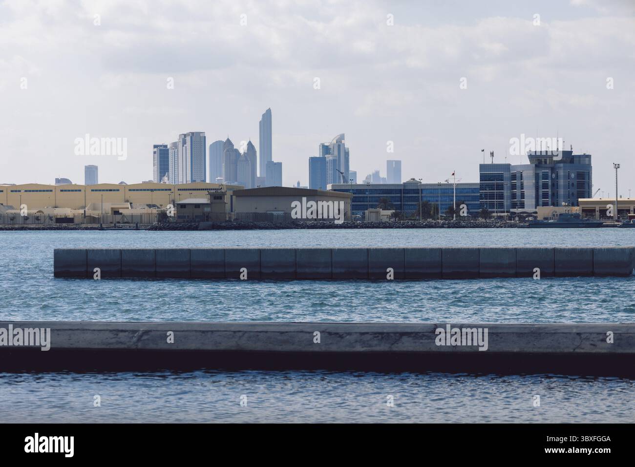 Blick auf die Stadt mit Türmen und Wolkenkratzern von Saadiyat Island in Abu Dhabi, Vereinigte Arabische Emirate. Blick von der Wasseroberfläche. Stockfoto