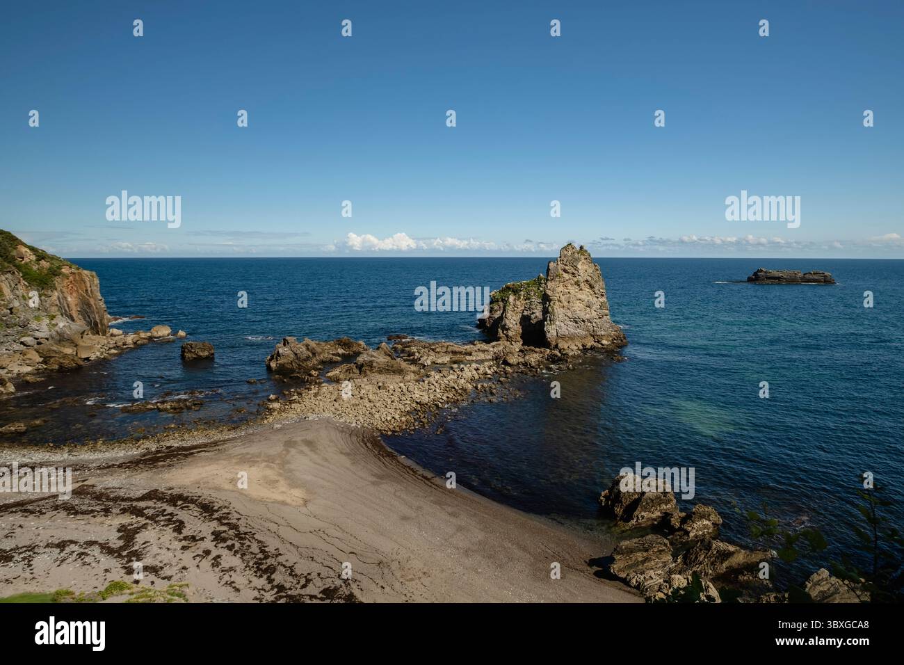 Die Insel Los Picones am Strand El Castiellu mit ihrem charakteristischen Kieselsteinisthmus, der bei Ebbe in Pendueles, der Westküste Asturiens, im Norden sichtbar ist Stockfoto