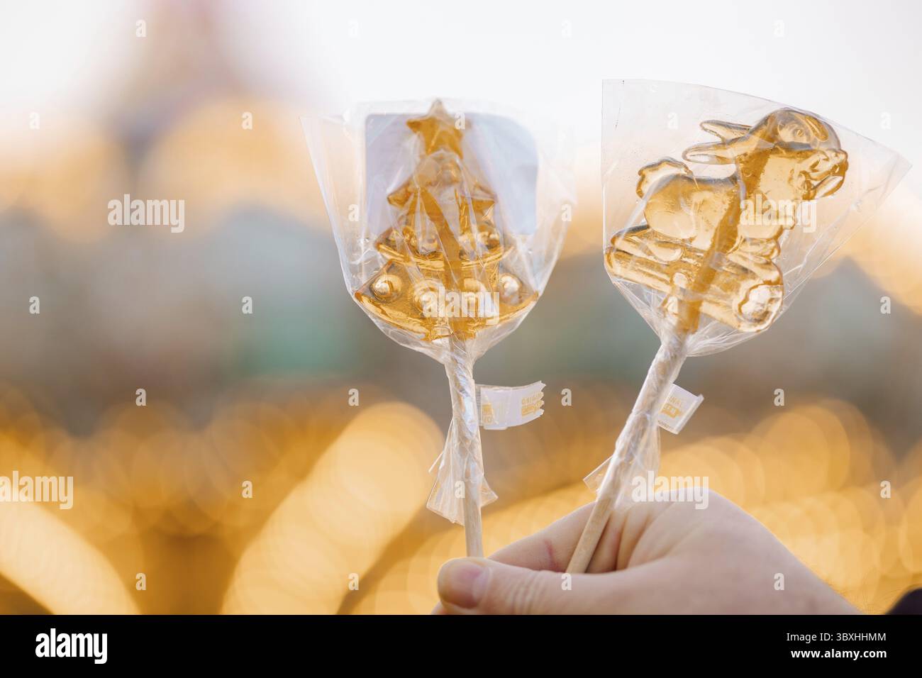 Hand hält goldene Weihnachtslutscher am Stock. Stockfoto