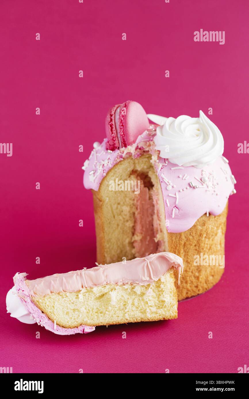 Osterkuchen – der traditionelle russische und ukrainische Kulich ist mit Makronen und Marschmalchen auf karmesinrotem Hintergrund dekoriert. Paska Osterbrot. Frohes e Stockfoto