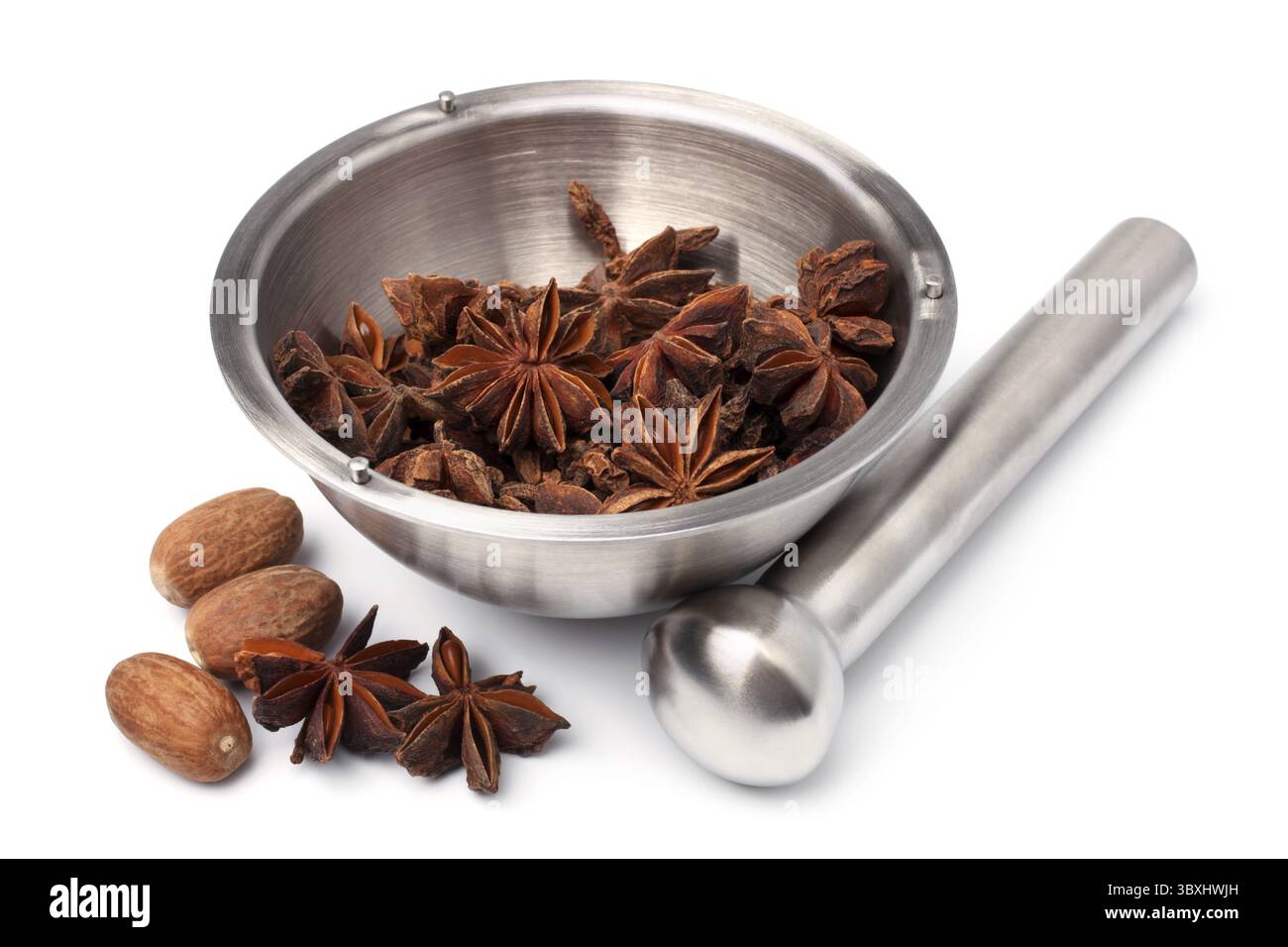 Mörser und Pissel mit Anissternen und Muskatnuss auf weißem Hintergrund Stockfoto