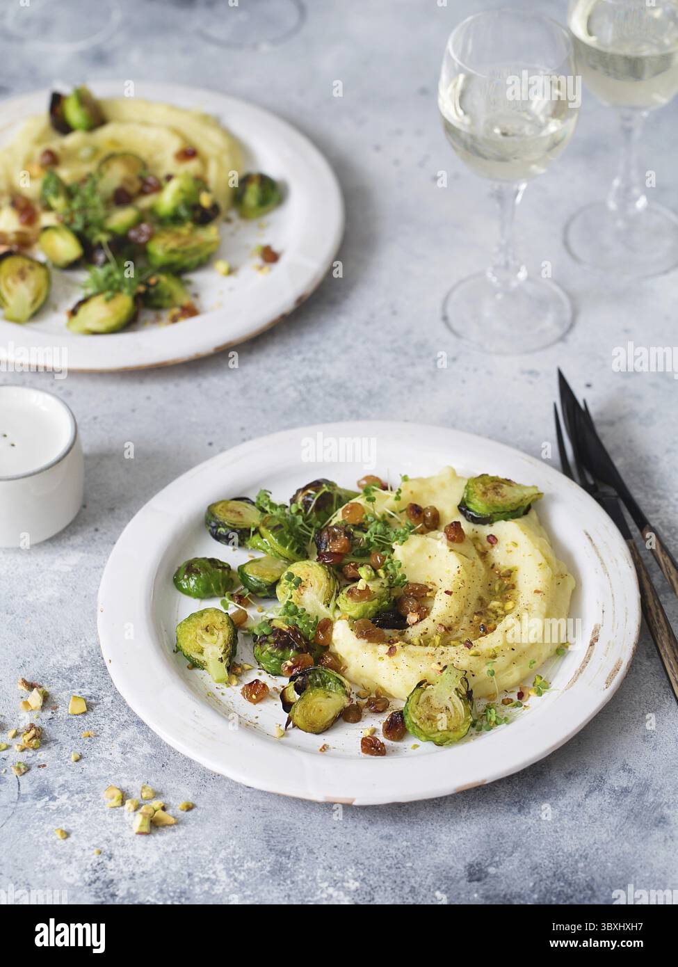 Rosenkohl mit Pistazien, Rosinen und Skordalia (Kartoffelpüree). Gesunde Zubereitung von Mahlzeiten. Gerichte auf pflanzlicher Basis. Grünes Leben. Veganes Rezept. F Stockfoto