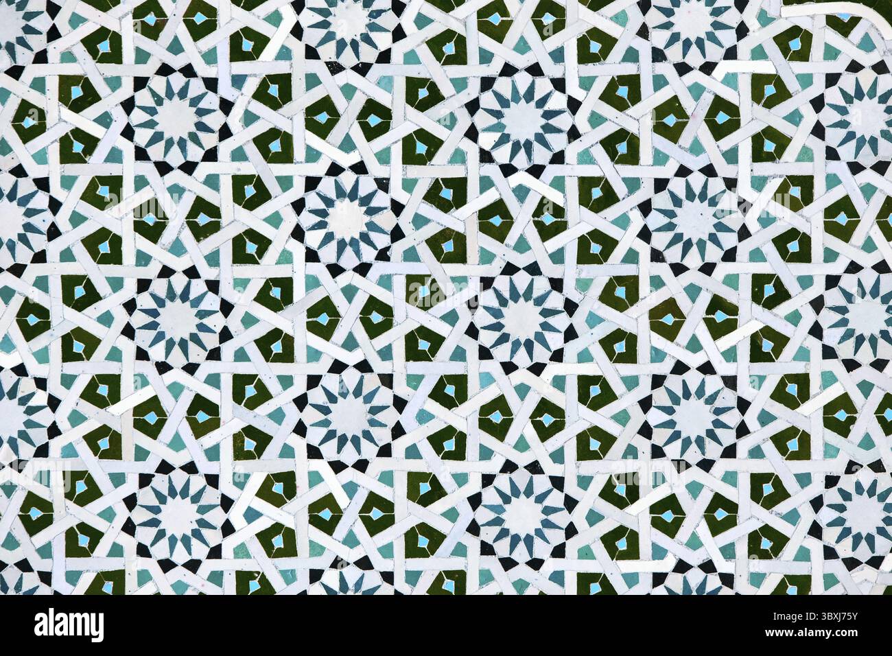 Ein detailliertes islamisches geometrisches Mosaik mit lebhaften Farben und symmetrischen Mustern. Das Design zeigt traditionelle Arabesken-Motive mit Sternscha Stockfoto